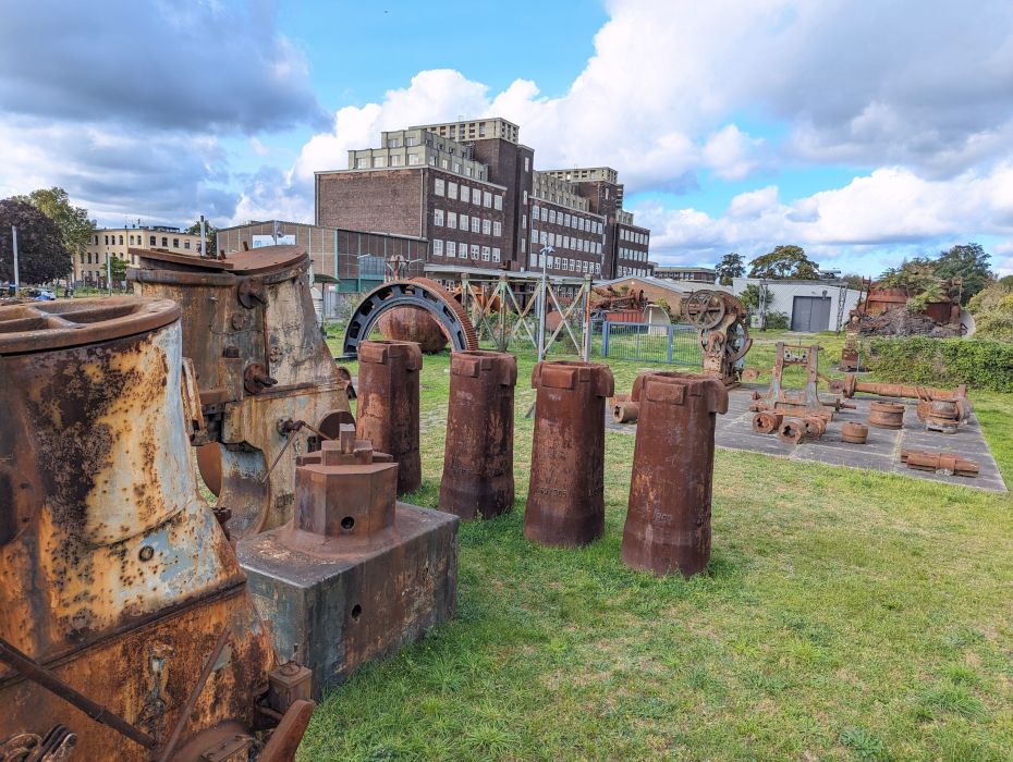 Op het terrein van het Peter Behrens-gebouw geven historische machines individuele werkprocessen in de zware industrie weer.