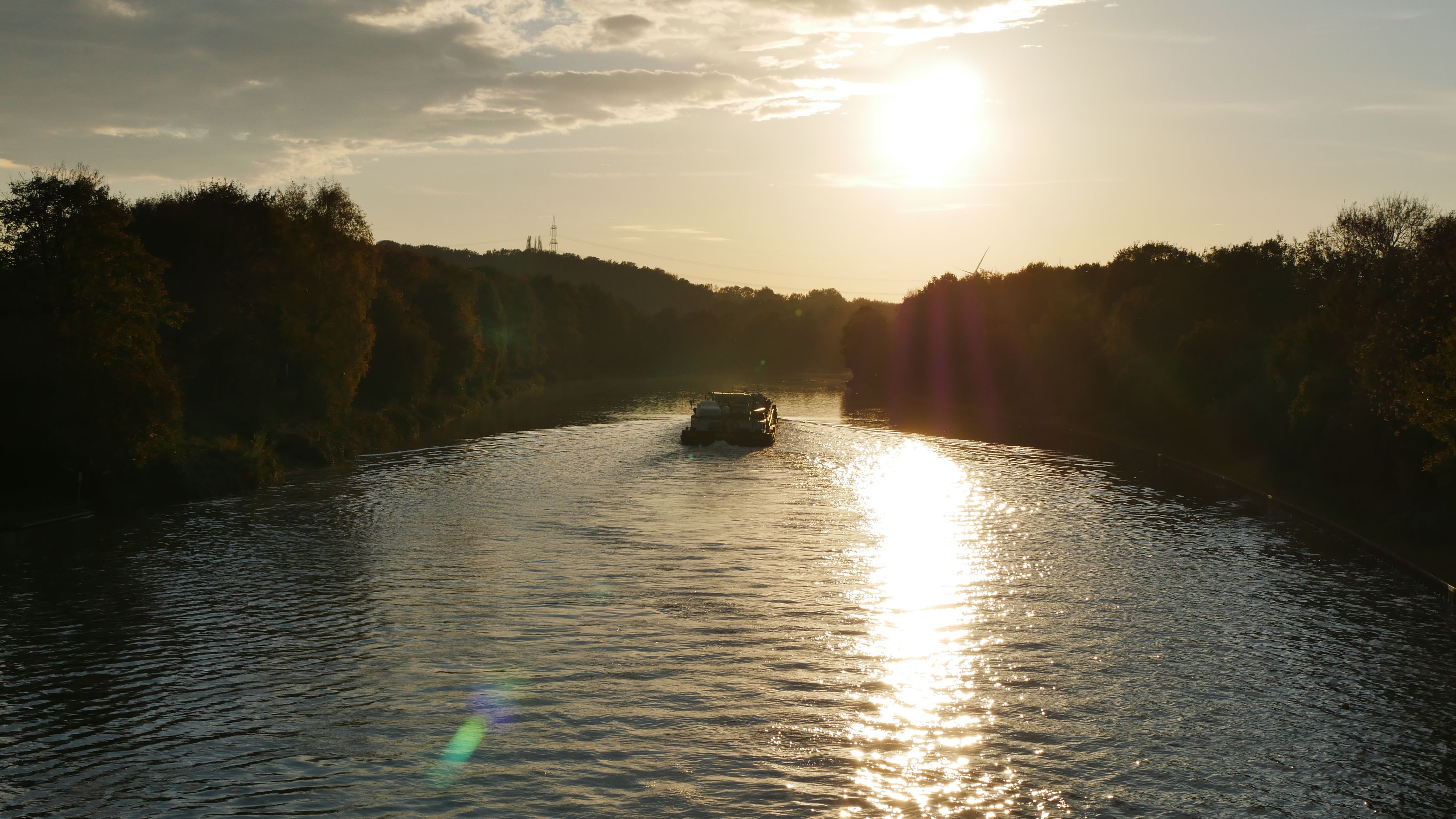 Schiff fährt auf Kanal in Abendsonne