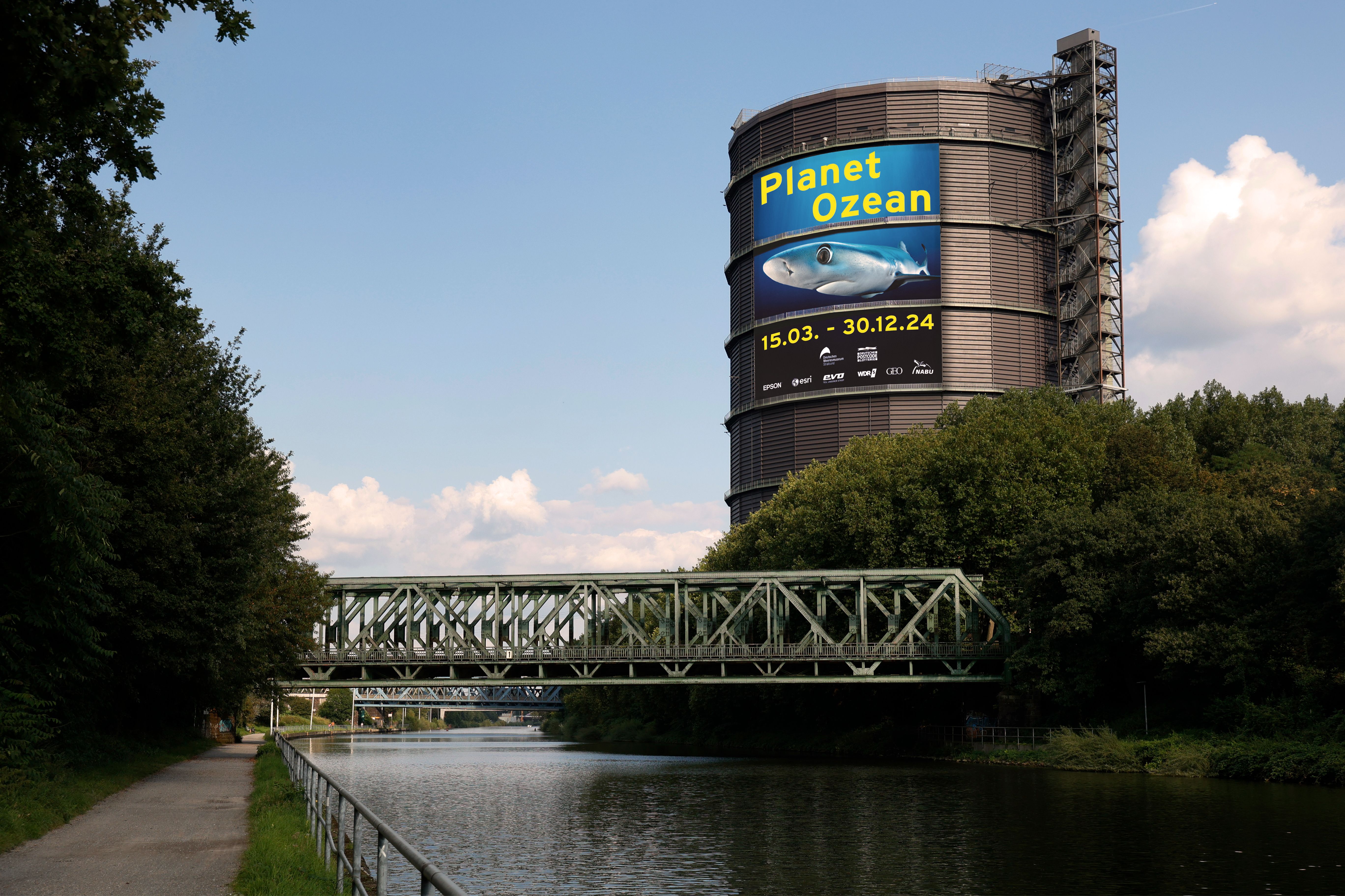 Een grote poster op het Rijn-Herne-kanaal wijst op de tentoonstelling Planet Ocean in de Gasometer