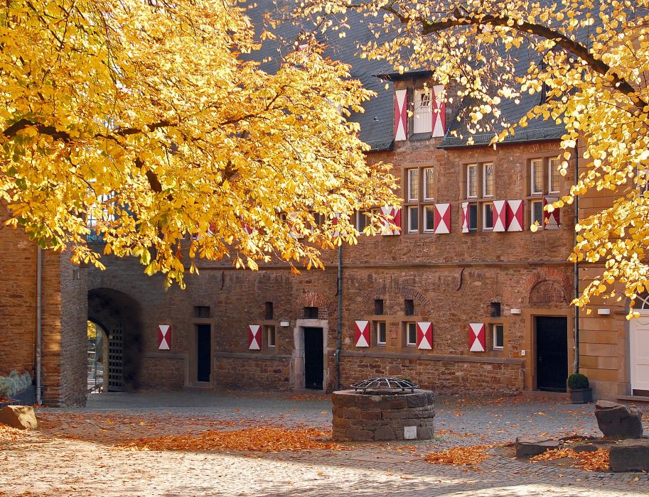 De binnenplaats van Kasteel Broich schittert in prachtig geel en oranje in de herfst