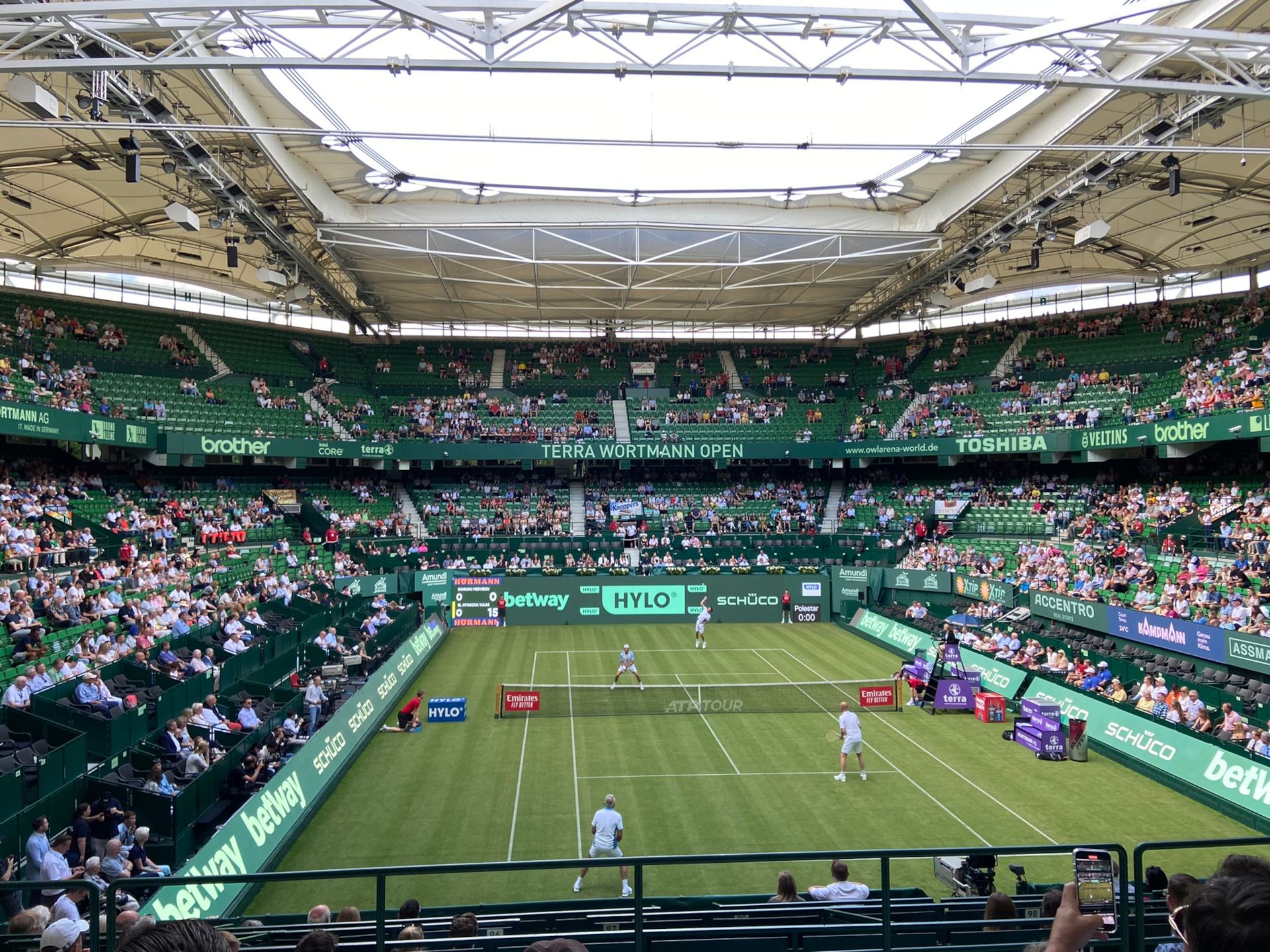 Toeschouwers kijken opgewonden naar de tennisbaan. Sterren van de scène strijden in individuele wedstrijden