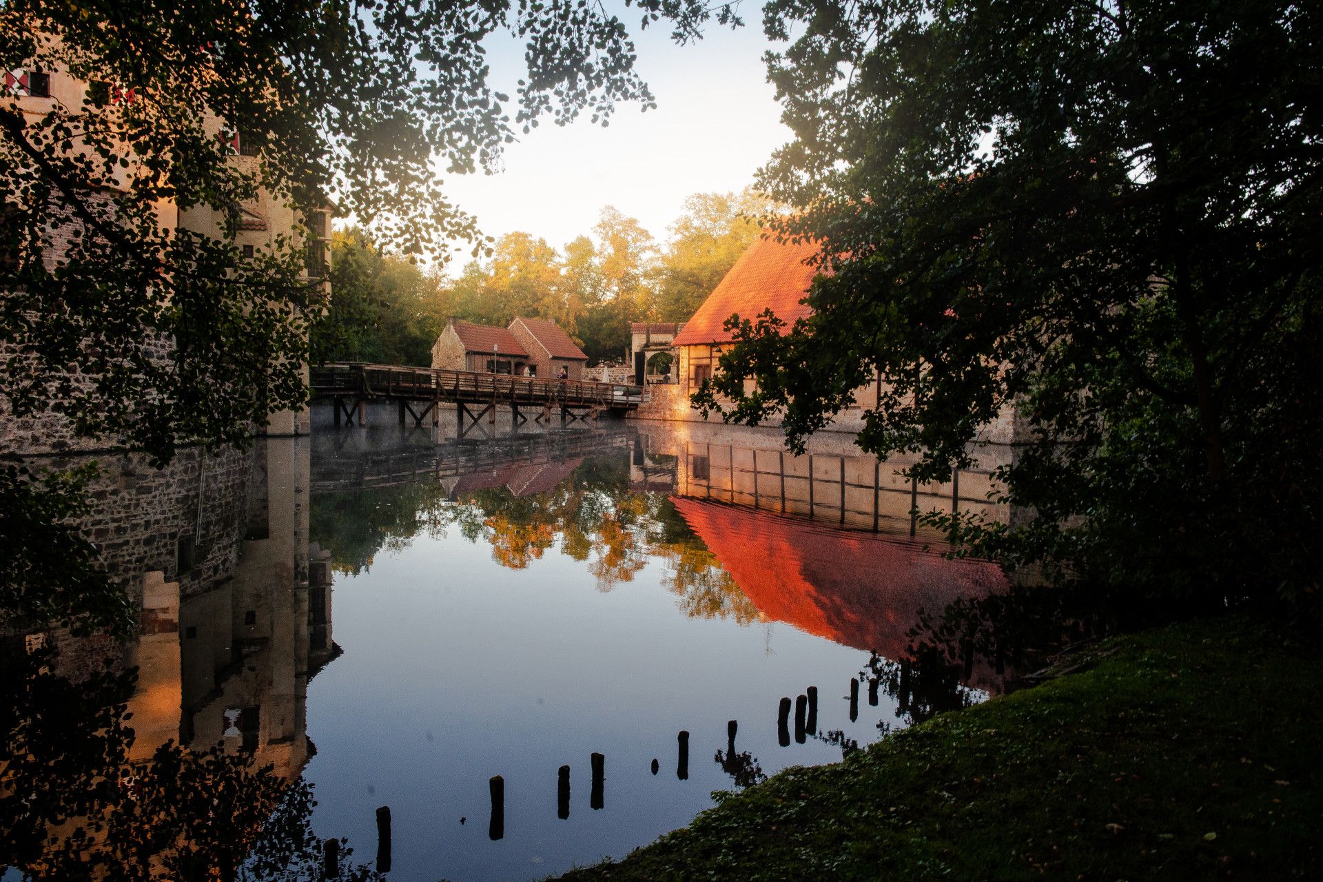 Burg Vischering Brücke vom Ufer mit Sonne